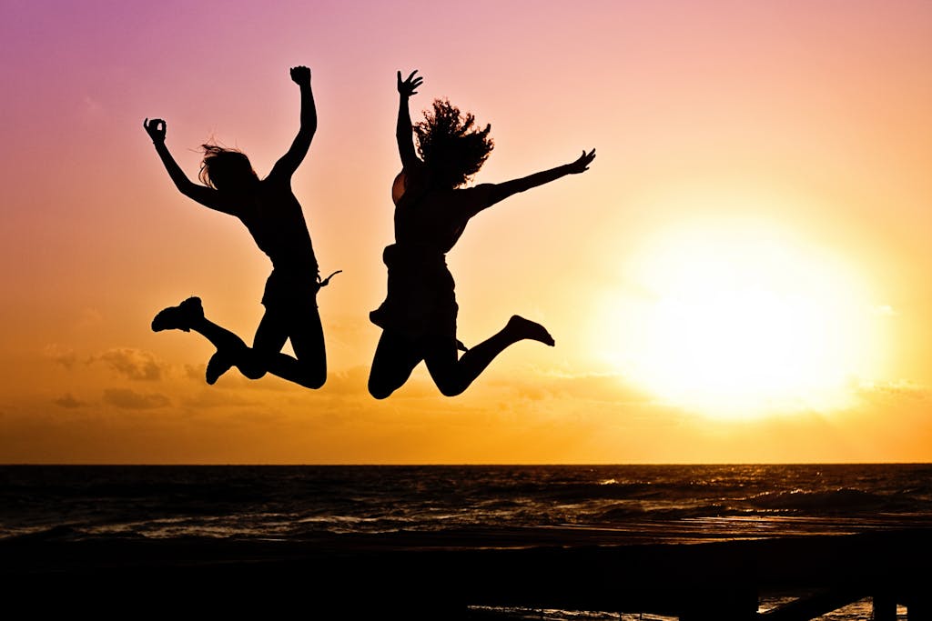 Silhouette Photography Of Jump Shot Of Two Persons