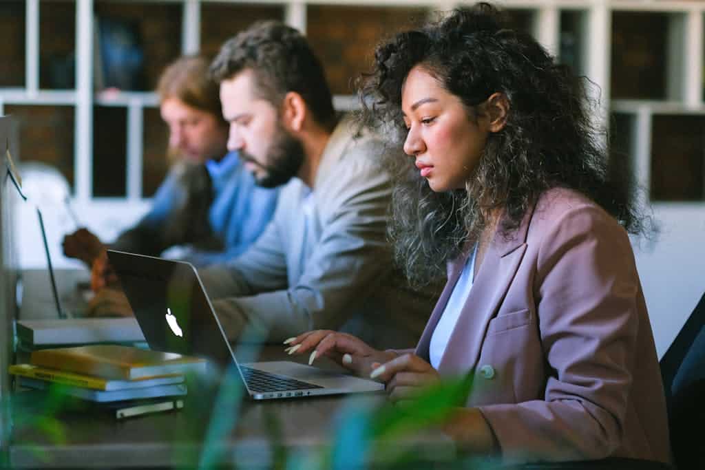 Focused colleagues working on laptops in office