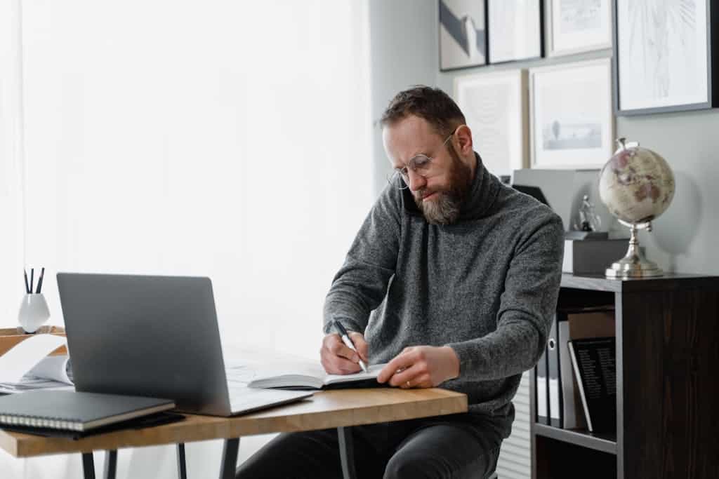 Man in Gray Sweater Sitting on Chair