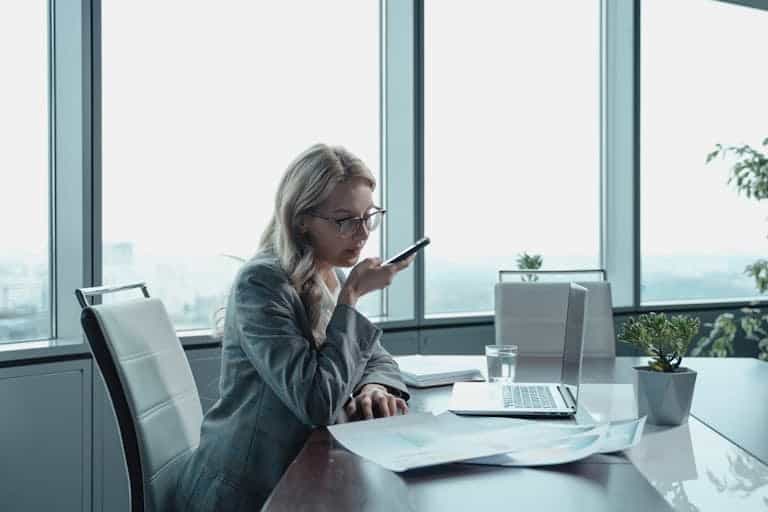 Woman in Gray Jacket Sitting on Chair Using Macbook