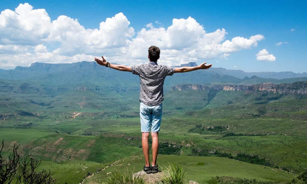 Man Wearing Grey Shirt Standing on Elevated Surface